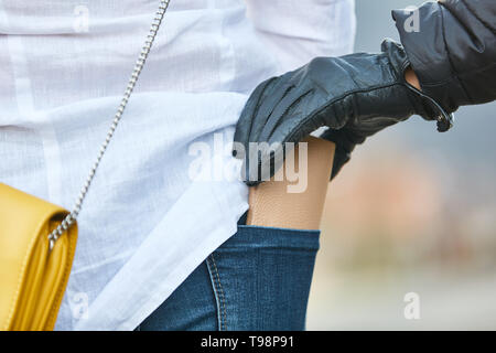 Thief stealing wallet from a trouser pocket Stock Photo