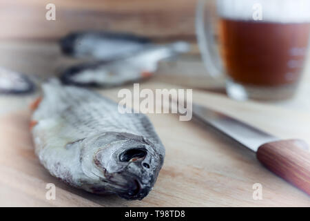 Dried roach on the table on the cutting Board and beer Stock Photo