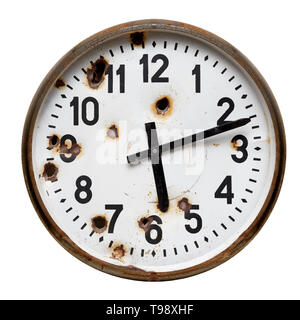 Isolated object: old rusty round wall clock with gun shot holes, close-up shot on white background, crime and violence concept Stock Photo