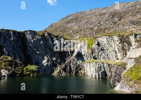 Steep sided flooded disused slate quarry pit on route to Carnedd Moel Siabod mountain in Snowdonia National Park. Capel Curig Conwy Wales UK Britain Stock Photo