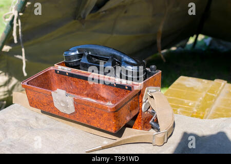 old military wired phone stands on the table in the army tent Stock Photo