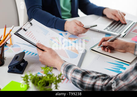 Business people discussing the charts and graphs showing the results of their successful teamwork.  Stock market chart and finger pointing on tablet i Stock Photo