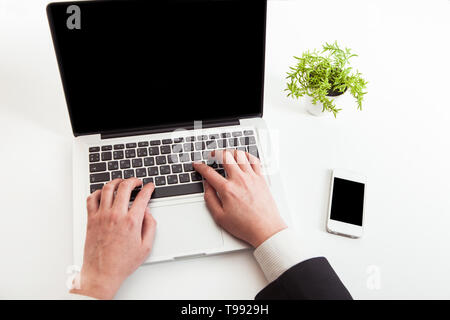 Man hand on laptop keyboard with blank screen monitor Stock Photo