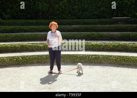 A dog owner looking at her smartphone. Stock Photo