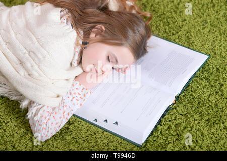 Portrait of cute tired schoolgirl sleeping after studying at home Stock Photo