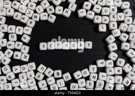 word, support, Word SUPPORT on wooden cubes on a black wooden table with copy space Stock Photo