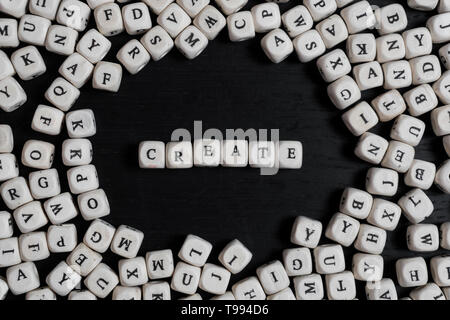 Word CREATE on wooden cubes on a black wooden table with copy space Stock Photo