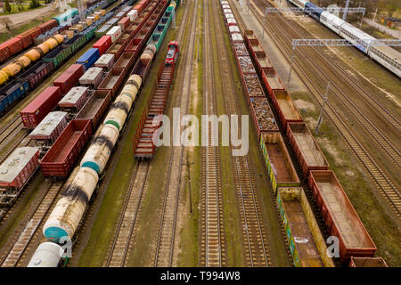 Aerial view of colorful freight trains with goods on the railway station. Top view from flying drone Stock Photo