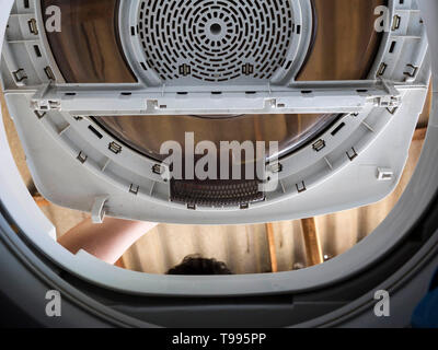 Man Doing Laundry from inside of washing machine Stock Photo