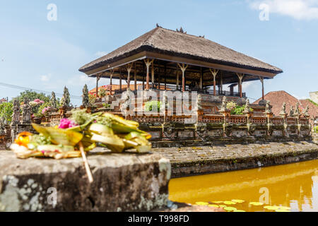 Traditional Balinese offerings canang sari near Bale Kembang (Floating pavilion) at Taman Gili Kertha Gosa, Semarapura, Klungkung, Bali, Indonesia Stock Photo