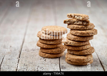 Two stacks of fresh baked oat cookies on rustic wooden table background. With copy space. Stock Photo