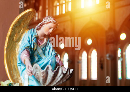 the Virgin Mary statue in church with sun light from top window, christian religion Stock Photo