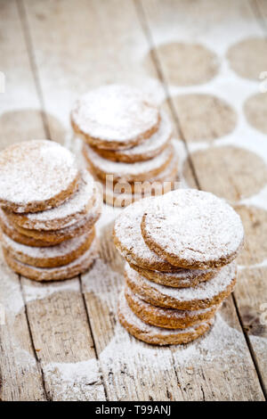 Fresh oat cookies stacks with sugar powder on rustic wooden table background. With copy space. Stock Photo