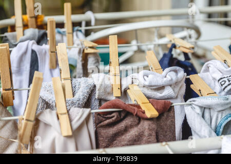White and colored linen to be dried on the clothesline with wooden clothespins Stock Photo