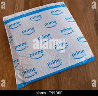 A white padded envelope showing a blue Amazon 'Prime' logo. Stock Photo