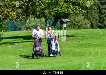 Two golfers on the way on fairway enjoying a golfgame Stock Photo