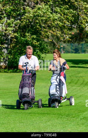 Two golfers on the way on fairway enjoying a golfgame Stock Photo