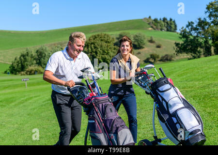 Two golfers on the way on fairway enjoying a golfgame Stock Photo