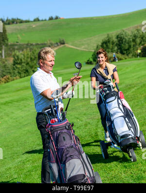 Two golfers on the way on fairway enjoying a golfgame Stock Photo