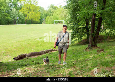 man with dog enjoying in funny walking outdoors. Stock Photo