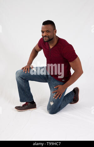 Happy black man kneeling Stock Photo