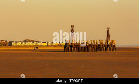 the beach at st annes on sea in the evening sunshine the pier with the st annes beach huts in the background Stock Photo