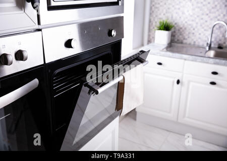 Opened New Electric Oven With Napkin Hanging On It Stock Photo