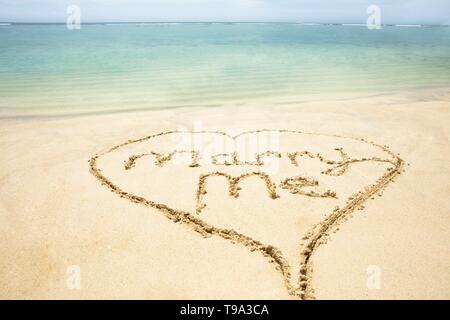 Close-up Of Marry Me Text Inside The Heart On Sand At Beach Stock Photo