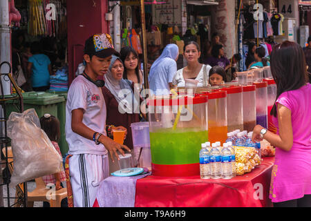 A boy selling freshly squeezed juice on the market in Kuching, Malaysia Stock Photo