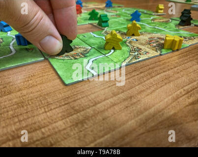 Turin, Piedmont, Italy. May 2019. Strategy board game, set inspired by the medieval town of Carcassonne in France. The players move around the field t Stock Photo