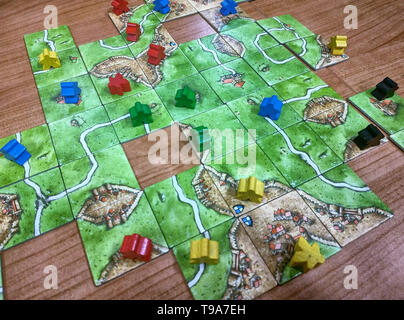 Turin, Piedmont, Italy. May 2019. Strategy board game, set inspired by the medieval town of Carcassonne in France. The players move around the field t Stock Photo