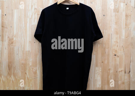close up black t-shirt cotton man pattern on wooden background Stock Photo