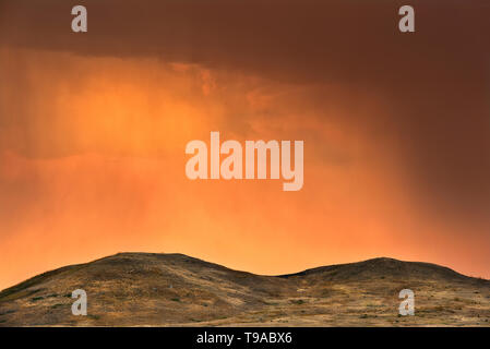 Storm light at sunrise over rolling hills of mixed-grass native prairie Grasslands National Park Saskatchewan Canada Stock Photo