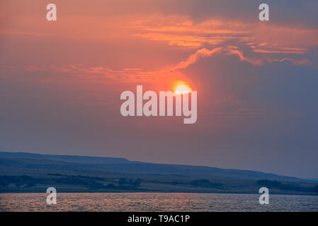 South Saskatchewan River and rolling hills of mixed grass prairie with storm clouds at sunrise Saskatchewan Landing Provincial Park Saskatchewan Canada Stock Photo