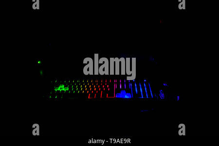 illuminated mea mechanical computer keyboard at nigh and hands waitingto start play the game. Stock Photo