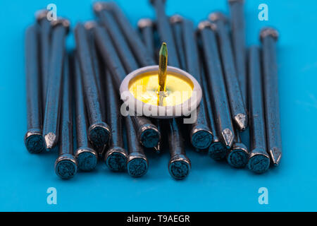 golden thumbtack on top of silver nails, diy success concept Stock Photo