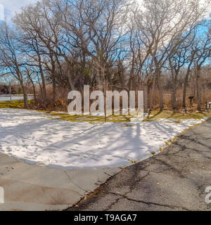 Clear Square Table and benches at a snowy picnic area near a lake on a sunny winter day Stock Photo