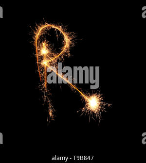 Sparklers forming letter R on dark background Stock Photo