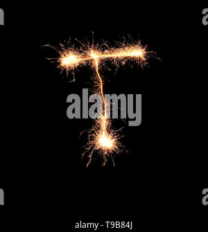 Sparklers forming letter T on dark background Stock Photo