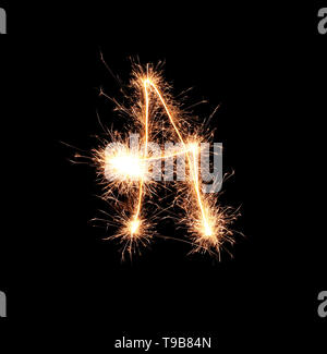 Sparklers forming letter A on dark background Stock Photo