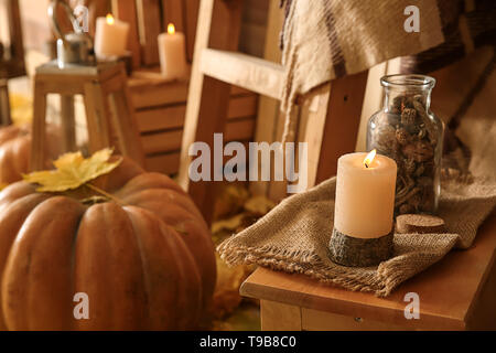 Burning candle on wooden table in room Stock Photo