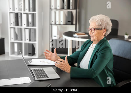 Elderly woman after making mistake during work with laptop Stock Photo