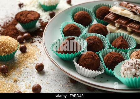 Plate with different tasty chocolate truffles on table Stock Photo