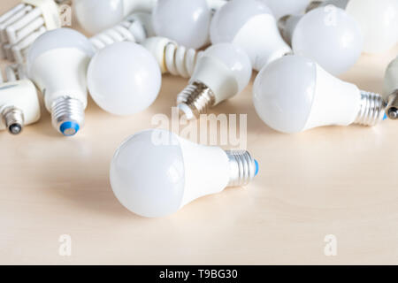 different LED bulb lights and energy-saving lamps on table Stock Photo