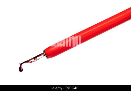 side view of red ink drop dripping from pointed tip of dip pen cut out on white backgroundA Stock Photo