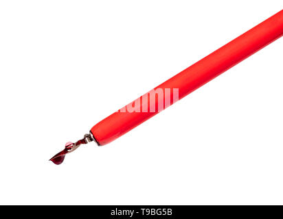 side view of red ink drop and bubble on the nib of dip pen cut out on white background Stock Photo