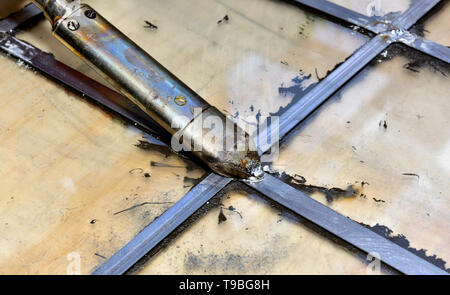 Soldering lead came in a leaded glass window pain with electric soldering iron Stock Photo