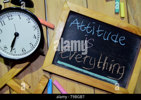 Attitude is Everything on phrase colorful handwritten on chalkboard and alarm clock with motivation, inspiration and education concepts. Table backgro Stock Photo