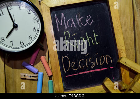 Make Right Decision on phrase colorful handwritten on chalkboard and alarm clock with motivation, inspiration and education concepts. Table background Stock Photo