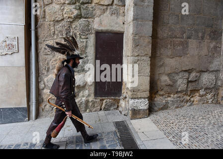 A Zarron seen walking on the streets during the festival in Almazan. El Zarron of Almazan Festival is a shepherd’s tradition just over 200 hundred years old that honours Saint Pascual Bailon. On its origins shepherds founded a Saint Pascual Bailon brotherhood and started parading a figure representing their Saint around the village. El Zarron is a character that represents the shepherds and wears beard, a hat with vulture feathers and a sheep or fox tail and leather clothes. Members of the brotherhood throw sweets ahead of the procession, and the Zarron has to clear the way of young people wit Stock Photo